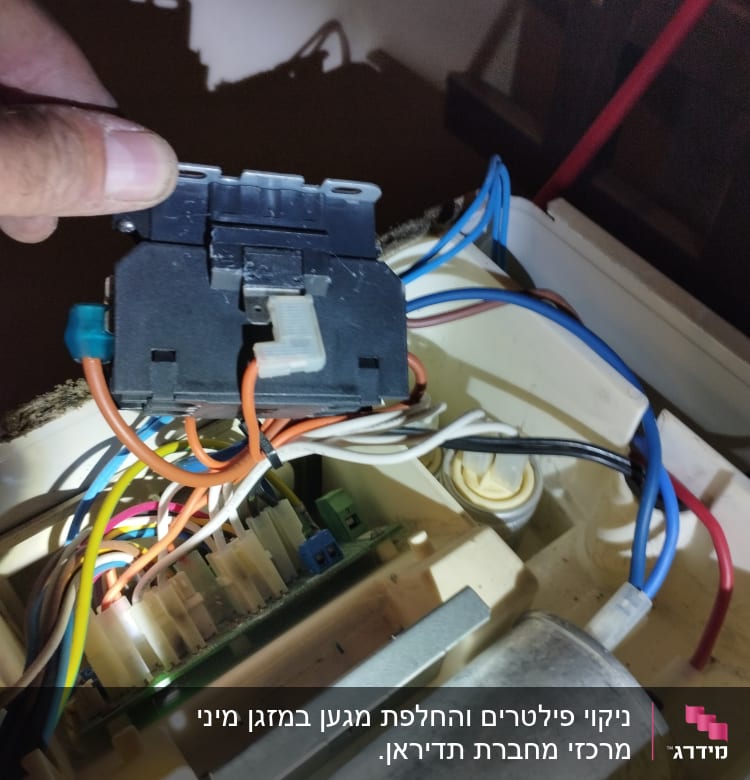חוטי חשמל מחוברים לרכיב במזגן
